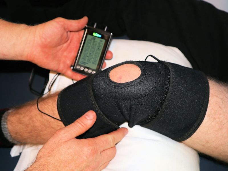 Physiotherapist assessing a patient knee during sports medicine consultation