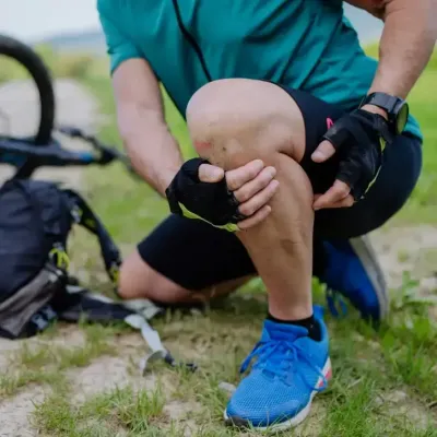 Athlete kneeling and holding an injured knee