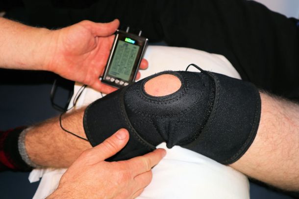 Physiotherapist assessing a patient knee during sports medicine consultation