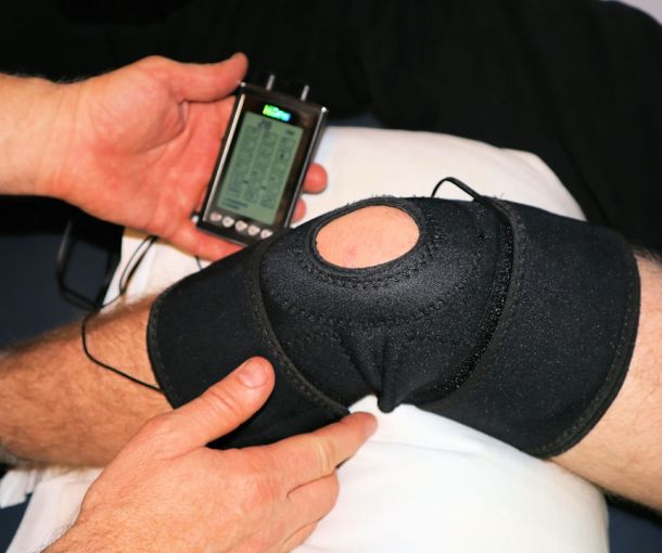 Physiotherapist assessing a patient knee during sports medicine consultation