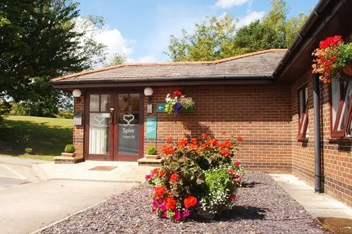 Entrance to Spire Yale Hospital, Wrexham, with flower beds by the door