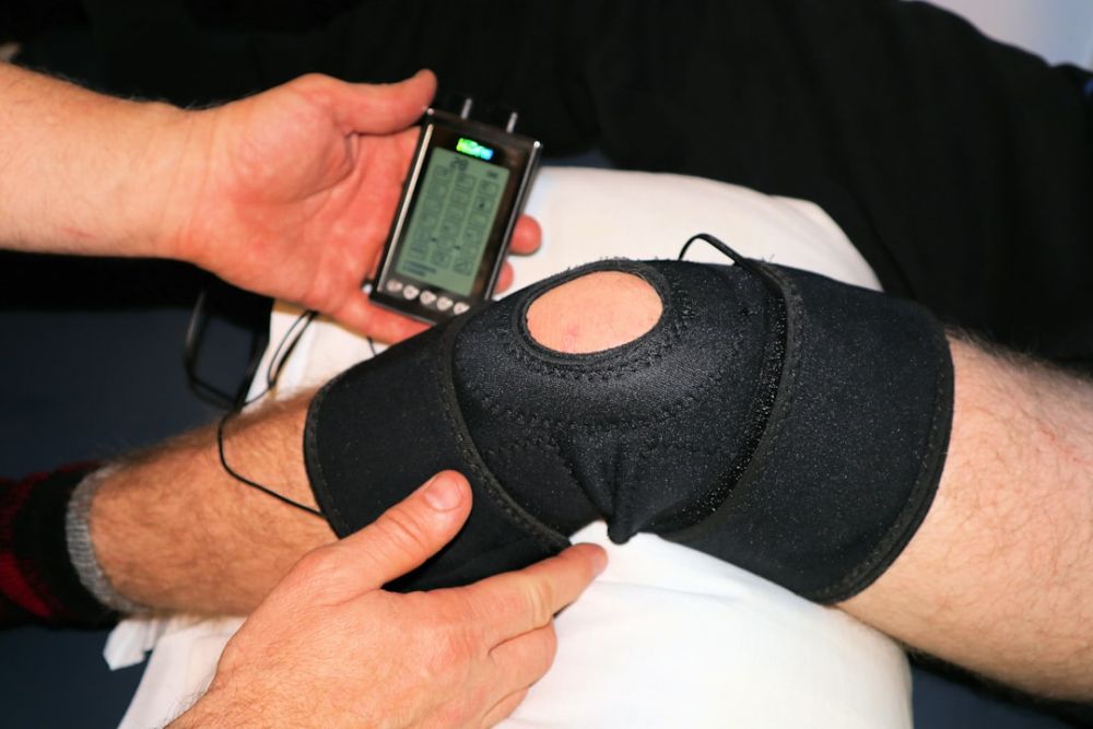 Physiotherapist assessing a patient knee during sports medicine consultation